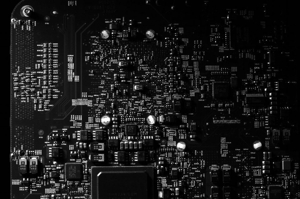 Detailed black and white photo of a circuit board showing intricate components, perfect for tech projects. Detailed black and white photo of a circuit board showing intricate components, perfect for tech projects.